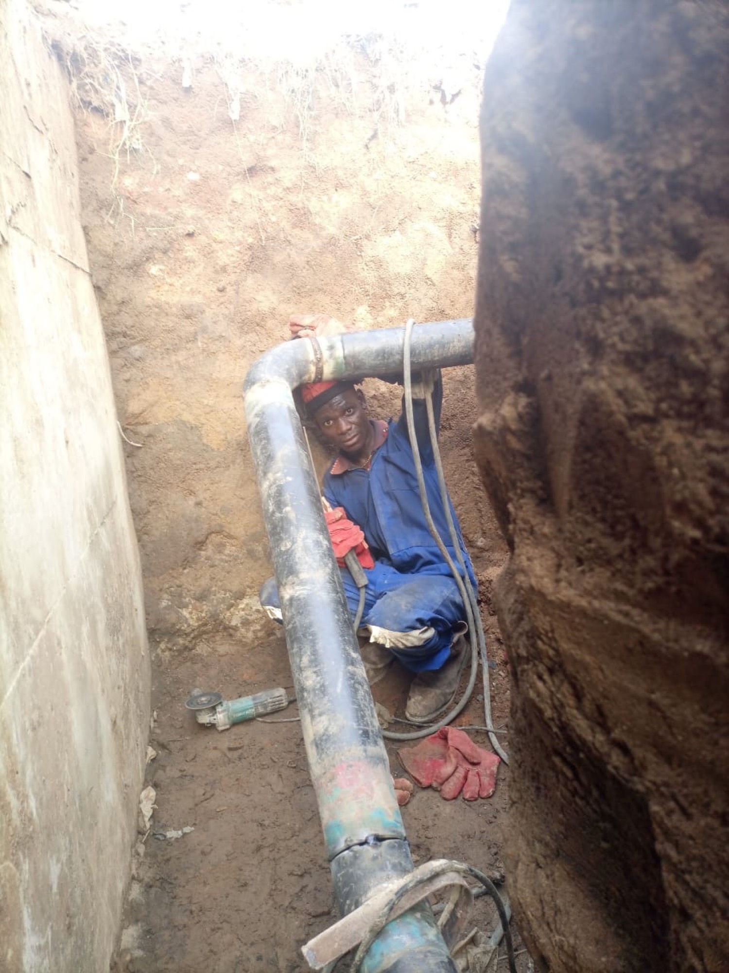 Worker in trench with pipe